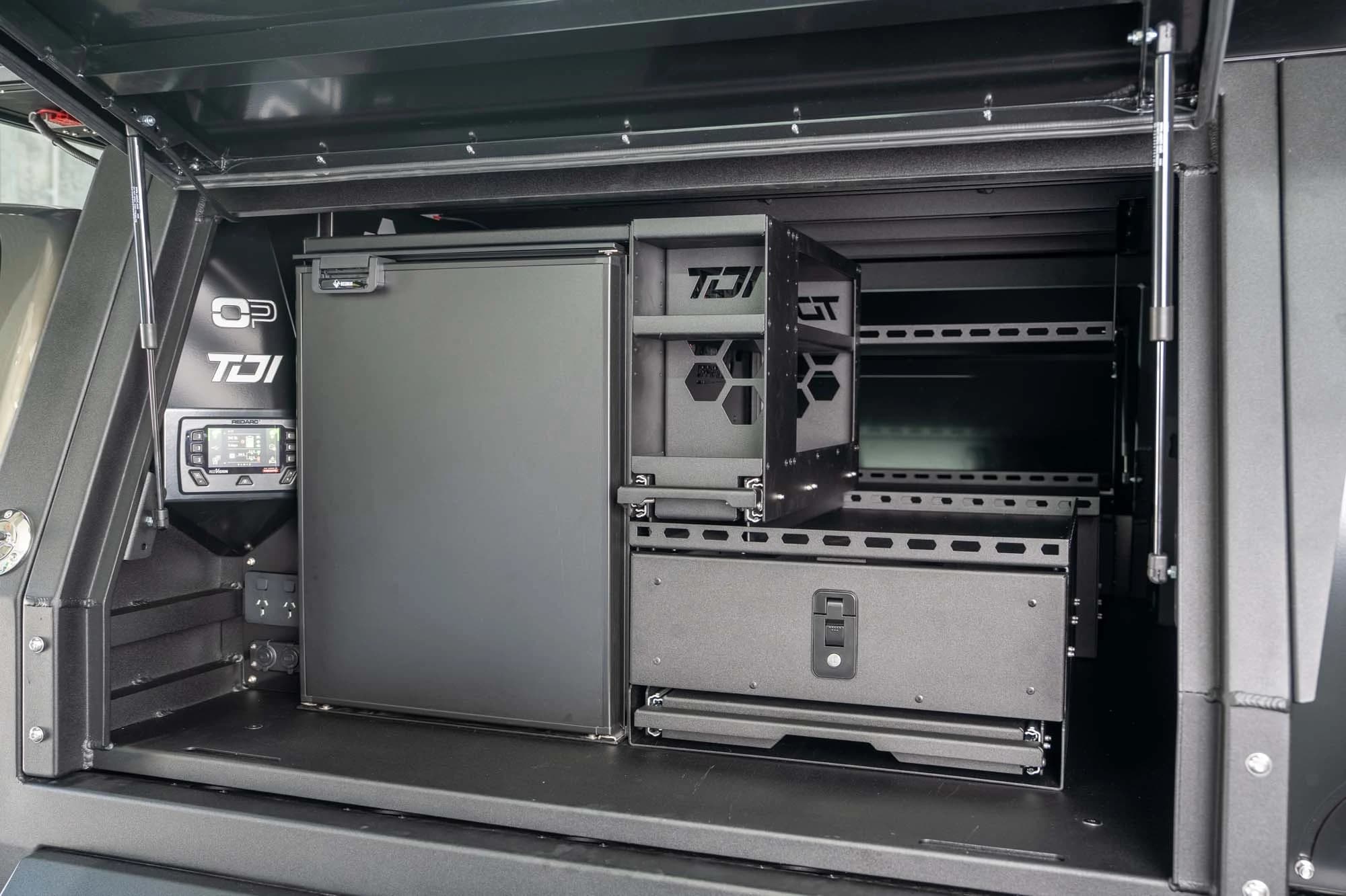 A tray canopy opened up on its fridge, drawer system and storage shelving.