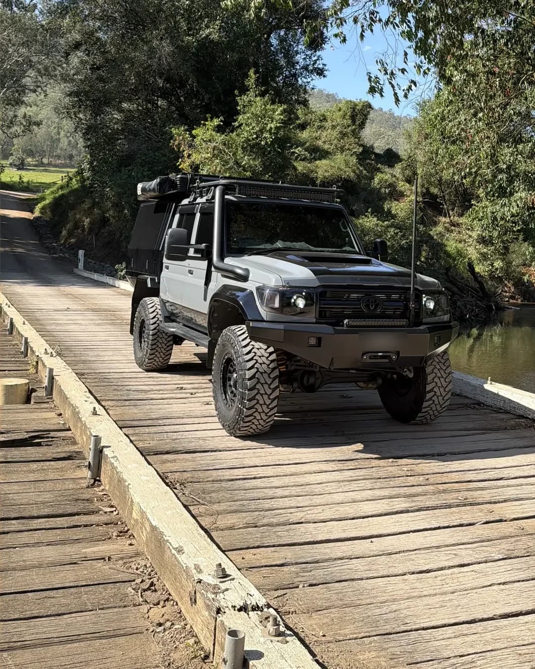 Drewsy's 79 crossing a narrow timber bridge under the trees.