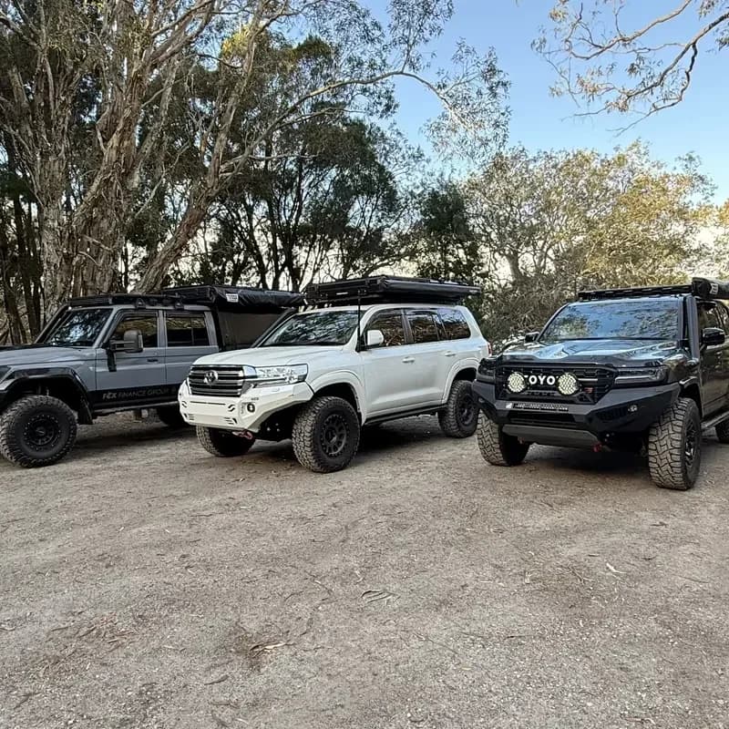 Three 4x4s lined up at a bush campsite.