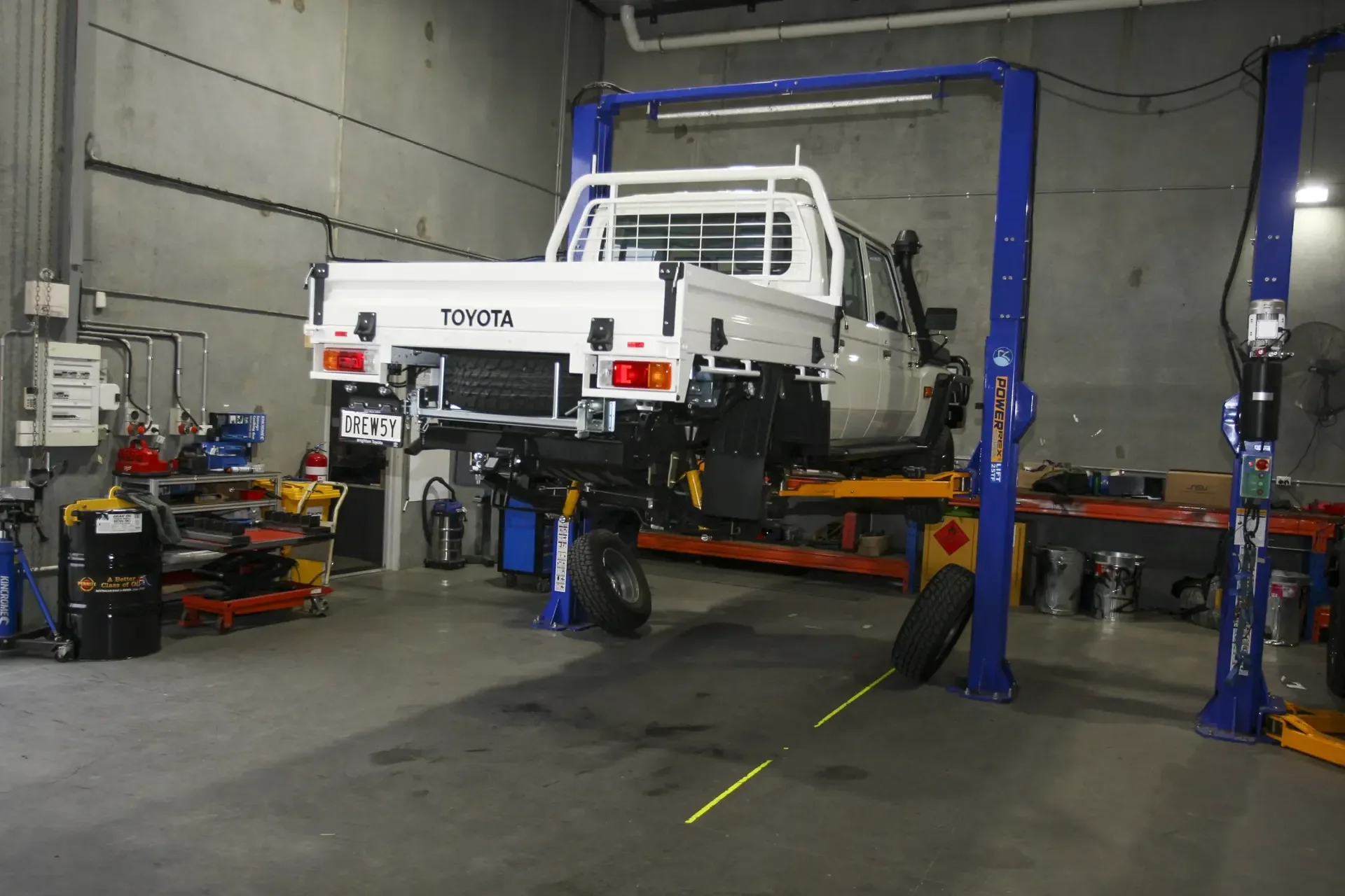 A tray-back 79 Series up on a workshop hoist, the wheels off mid-build.